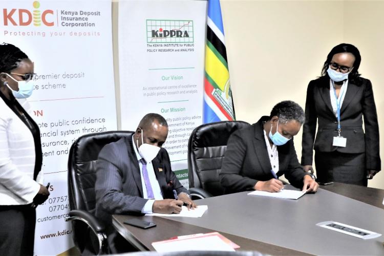 To a greater partnership....KDIC CEO Mr. Mohamud A. Mohamud & KIPPRA Exec. Director. Dr. Rose Ngugi put pen to paper during the signing of a collaborative MOU on empirical research between the two institutions. Looking on are KDIC’s Eunice Kitche,  Head of Legal (Left) and Caroline Mukiira, (Right)  Ag. Corporation Secretary, KIPPRA